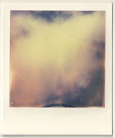 a polaroid photograph of the sky with clouds and stars in it's center