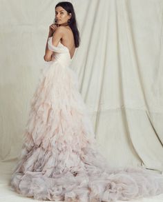 a woman in a wedding dress posing for the camera with her hand on her face