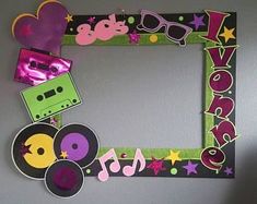 a photo frame made out of paper with music notes and cassettes on the side