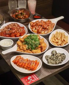 a table topped with lots of different types of food next to plates and bowls filled with sauces