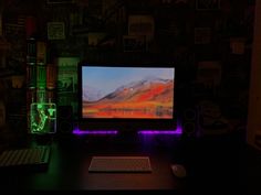 a desktop computer sitting on top of a desk next to a keyboard and mouse in a dark room