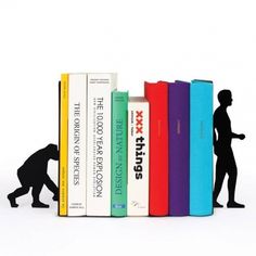 a small figurine standing next to a row of books on top of each other