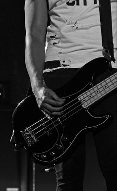 a man holding a bass guitar on stage