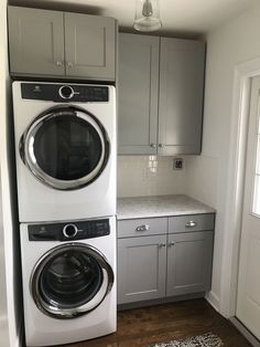 Small laundry room with Electrolux appliances, quartz counters, subway tile, and oak floors.