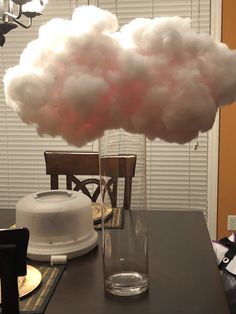 a cloud is floating in a glass vase on a table