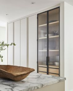 a large bowl sitting on top of a counter next to a book shelf filled with books