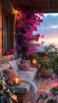 a balcony with flowers and candles on the table, next to it is a couch