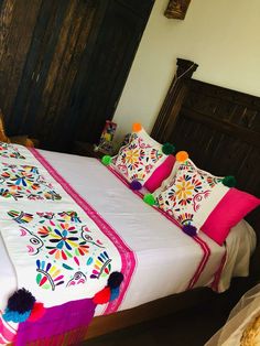 a bed with colorful pillows and blankets on it