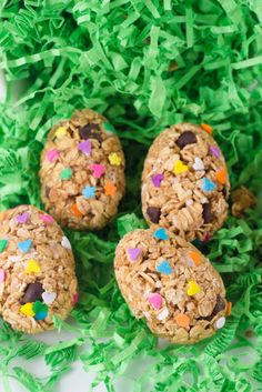 a bowl filled with cookies and sprinkles on top of green shredded grass