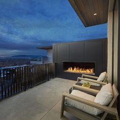 a balcony with two chairs and a fire place