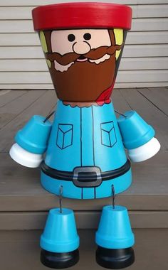 a blue plastic toy with a beard and mustache on it's head, sitting on a porch