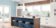 a kitchen with an island and three stools in front of the counter top, along with sliding glass doors leading outside