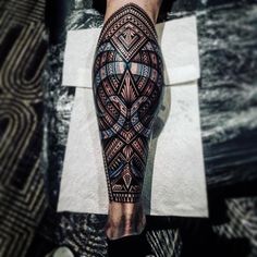 a man's leg with an intricate tattoo design on his leg and the legs