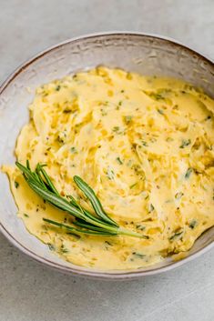 a bowl filled with cheese and herbs on top of a table