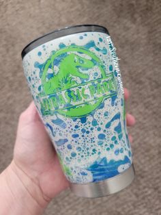 a hand holding a blue and green drink