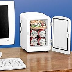 three different mini fridges sitting on top of a wooden table