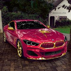 a red sports car parked in front of a white house with gold lettering on it