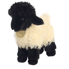 a black and white sheep stuffed animal with a tag on it's ear, standing upright