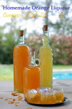 three bottles of orange liqueur sitting on a table next to an empty bottle