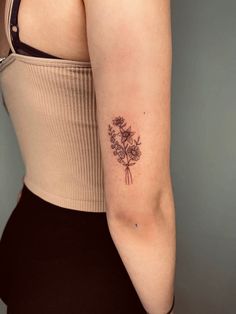 a woman with a flower tattoo on her left arm and right arm behind her back