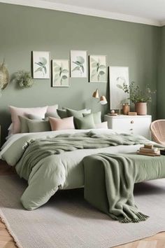 a bedroom with green walls and bedding in the center, along with pictures on the wall