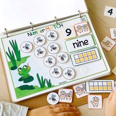 a child's hands are playing with matching numbers