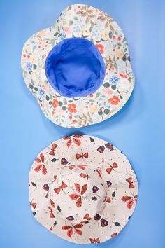 two plates with butterfly designs on them and one has a blue bowl in the middle