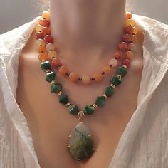 Make a statement with this Beautiful Natural Green Agate Pendant Necklace. This unique piece of jewelry features a stunning natural green agate pendant on a beaded layered necklace, made with a combination of orange agate and green acrylic beads. The pendant is the centerpiece of this necklace, featuring a gorgeous natural green agate stone that adds a touch of natural beauty. The orange agate and green acrylic beaded necklace adds an extra touch of brightness and style, creating a chunky and ey Beaded Orange, Hematite Jewelry, Acrylic Necklace, Natural Gemstone Necklace, Tiger Eye Jewelry, Mother Of Pearl Jewelry, Orange Agate, Chunky Statement Necklace, Agate Pendant Necklace