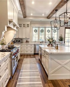 a large kitchen with white cabinets and wood flooring, along with an area rug