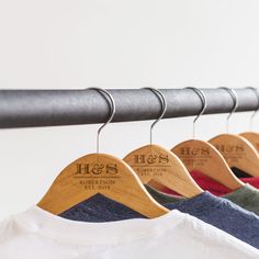 wooden clothes hangers with personalized shirts on them