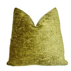 a green velvet pillow on a white background, with the back turned to reveal a textured pattern