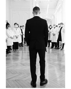 a man standing in front of a group of people wearing lab coats and white coats