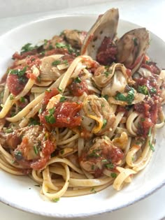 a white bowl filled with pasta and clams