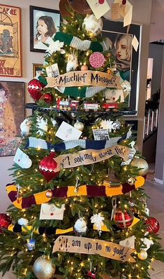 a decorated christmas tree in the middle of a room with pictures on the wall behind it