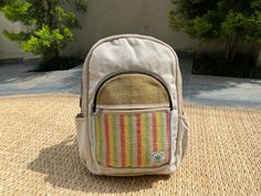 a small backpack sitting on top of a mat next to a tree and building in the background