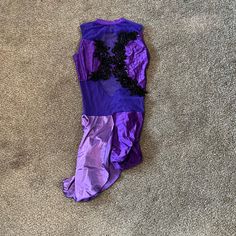 an upside down purple and black umbrella on the ground