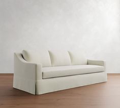 a white couch sitting on top of a wooden floor