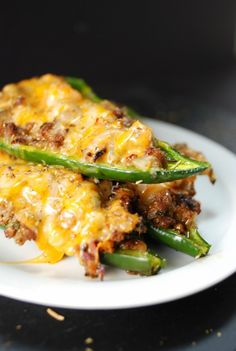 some green beans and cheese are on a white plate with black table cloth in the background