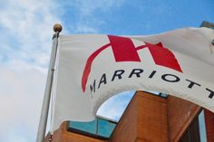 a white and red flag with the word marriott on it in front of a brick building