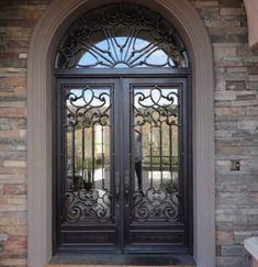 the front door to a home with wrought iron doors and glass panels on each side