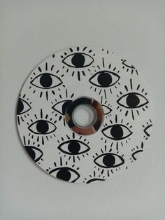 a white and black clock with an eye design on it