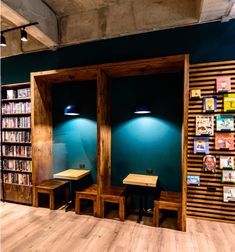 two wooden benches sitting in front of a book shelf