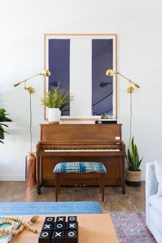 a living room filled with furniture and a piano in front of a mirror on the wall