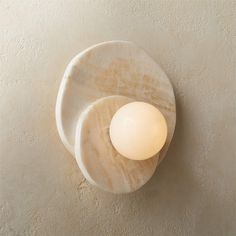 a light that is on the wall next to a white plate with an egg in it