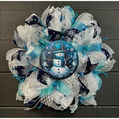 a blue and white wreath with a snowman on it