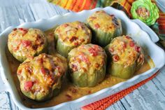 several stuffed peppers in a white casserole dish on top of a wooden table