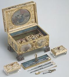 an elaborately decorated jewelry box with various items inside and outside the lid, including scissors