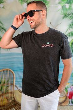 Dive into the essence of a beach sunset with The Evening Palm Tee. Designed for unisex wear, this cotton t-shirt is crafted from 100% combed cotton and weighs a lightweight 4.1 oz, offering ultimate comfort with a regular fit. The black tee features a Palmr logo on the front and a stunning beach sunset design on the back, screen-printed to capture the soulful vibes of the coast. With a stone wash finish for a worn look, this graphic t-shirt is more than just a piece of clothing—it’s a ticket to Summer Cotton T-shirt For Surfing, Beach Cotton T-shirt With Front Print, Cotton Beach Top With Back Print, Cotton Top With Back Print For Beach, Beachy Cotton T-shirt, Pre-shrunk, Beachy Cotton T-shirt, Black Relaxed Fit T-shirt For Surfing, Beachy Cotton T-shirt Pre-shrunk, Beachy Cotton Pre-shrunk T-shirt