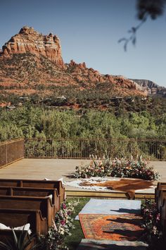 an outdoor wedding setup with flowers and greenery in front of a mountain view area