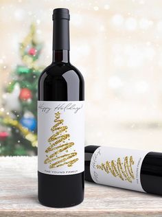 a bottle of wine with a christmas tree on it next to a corkscrew